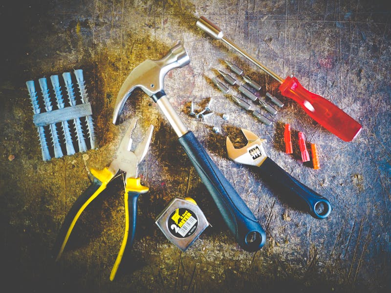 Various hand tools including wrenches and pliers laid out on a workbench